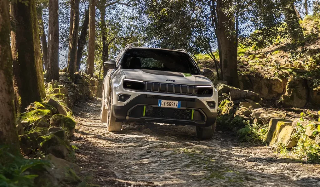 Jeeo avenger 4xe bianca e nera in un bosco offroad