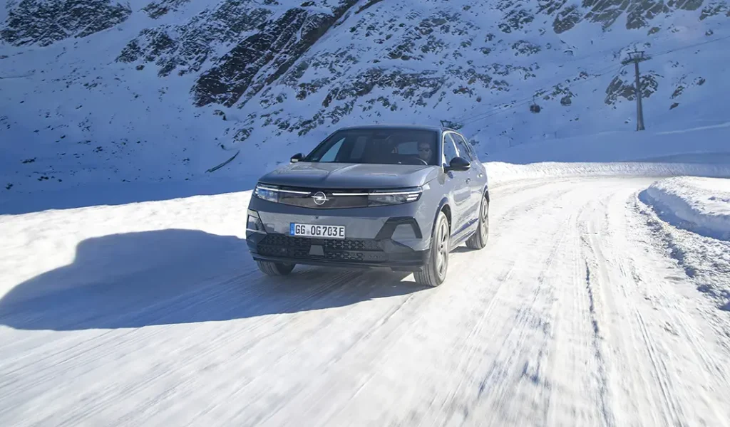 Opel Grandland Electric con trazione integrale che percorre una strada innevata di montagna