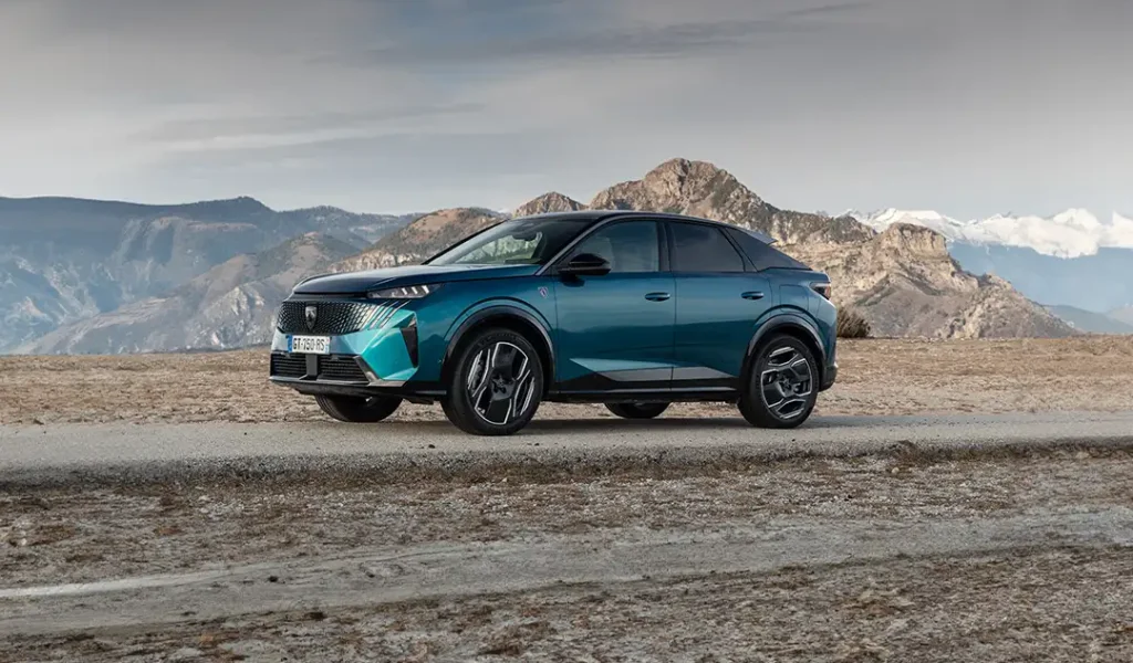 Peugeot 3008 azzura che percorre una strada offroad con montagne sullo sfondo